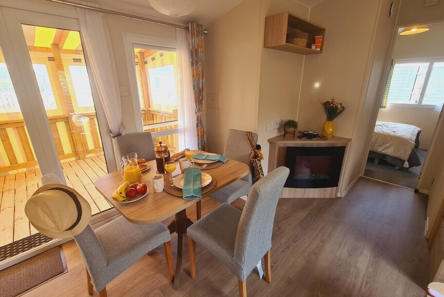 Eetkamer, keuken en slaapkamer van de Atlantique stacaravan te huur op de camping Pors Perón, camping in het zuiden van Finistère