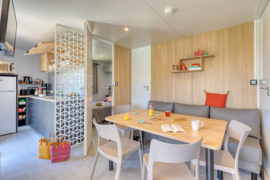 Eetzaal en keuken van de Grand Large stacaravan te huur op de Pors Perón-camping, camping in Bretagne